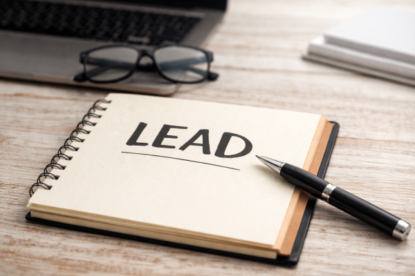 Notes z wyraźnie zapisanym słowem „LEAD” na pierwszej stronie, symbolizujący początek i wprowadzenie do artykułu informacyjnego.